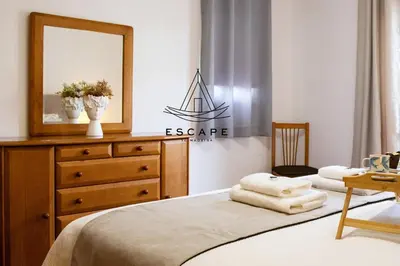 a bedroom with a bed with a dresser and a mirror at Anavrin by Escape to Madeira in Ponta do Sol