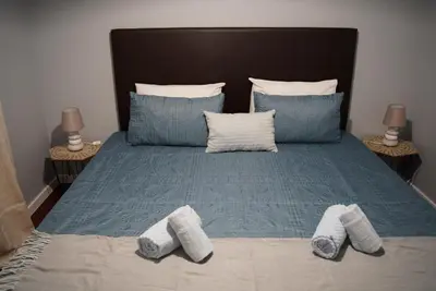 a bed with blue pillows and two pairs of socks on it at Atlantic Breeze - Free Parking in Funchal