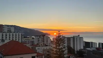 a view of a city with the sunset in the background at Atlantic Breeze - Free Parking in Funchal