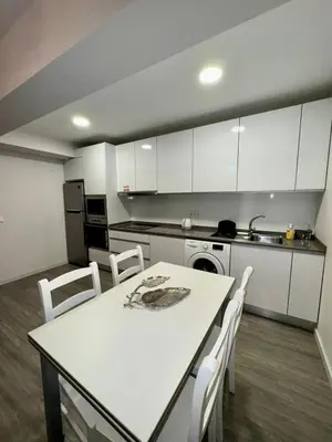 a kitchen with a white table and white cabinets at Alameda Formosa Madeira in Funchal