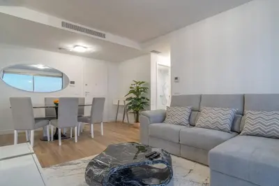 a bedroom with a large white bed and a large window at The Place Funchal View in Funchal