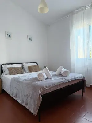 a white chair sitting next to a green shutter at Casa do Profeta in Porto Santo