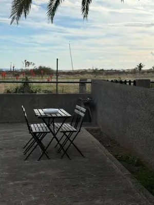 a table and two chairs sitting next to a wall at Casa do Profeta in Porto Santo