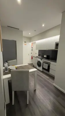 a white kitchen with a table and a microwave at Gold Center Funchal 101 in Funchal
