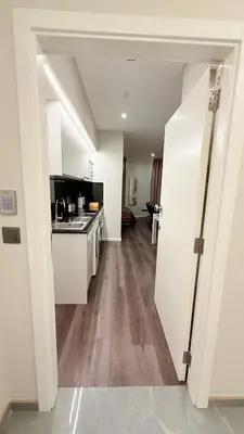a kitchen with white cabinets and a wooden floor at Gold Center Funchal 101 in Funchal