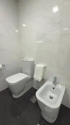 a white bathroom with a toilet and a sink at Gold Center Funchal 101 in Funchal