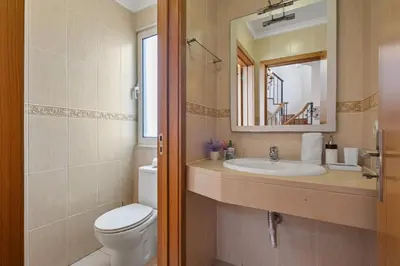 a bathroom with a toilet and a sink and a mirror at Villa Lucente by Homie in Santa Maria Maior