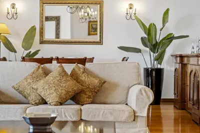 a living room with a couch with pillows and a mirror at Villa Lucente by Homie in Santa Maria Maior