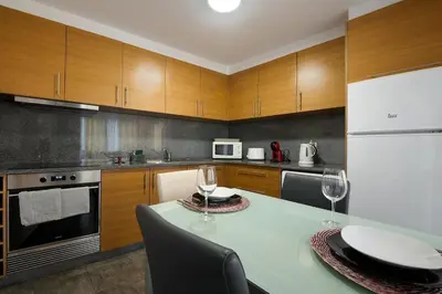 a kitchen with a table with two wine glasses on it at Casa Vereda do Calhau - With barbecue in Campanário