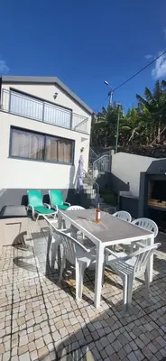 a white table and chairs in front of a house at Casa Vereda do Calhau - With barbecue in Campanário