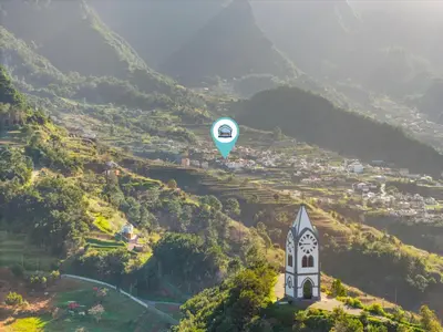 a hot air balloon flying over a hill with a church at Casa Refúgio M in São Vicente