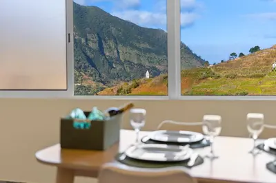 a table with two windows and a table with glasses at Casa Refúgio M in São Vicente