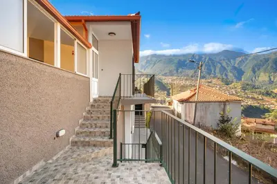 a staircase leading up to a house with mountains in the background at Casa Refúgio M in São Vicente