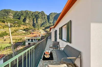 a balcony with a couch and a view of a mountain at Casa Refúgio M in São Vicente