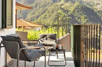 a pair of chairs and a table on a balcony at Casa Refúgio M in São Vicente