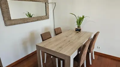 a dining room table with chairs and a mirror at Reis Magos View in Caniço