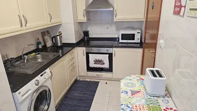 a small kitchen with a sink and a dishwasher at Reis Magos View in Caniço