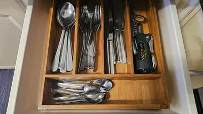 a wooden drawer with silver utensils in it at Reis Magos View in Caniço