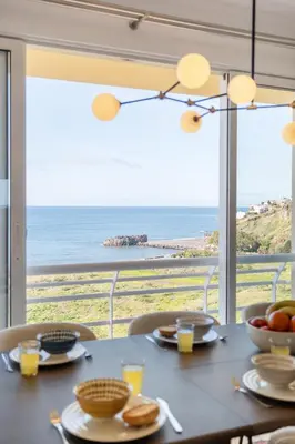 a dining table with a view of the ocean at Apartamento Paz e Sossego - By Wehost in Panasqueira