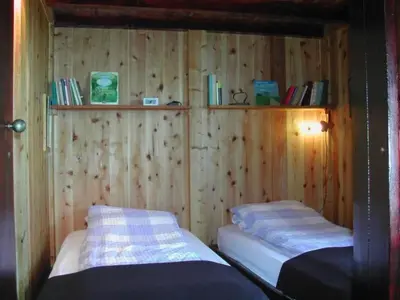 two beds in a room with wooden walls at Holiday Home in Canhas mit Schönem Garten by Interhome in Ponta do Sol