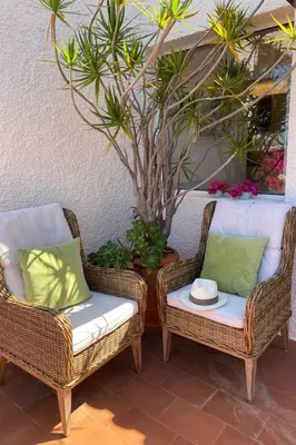 two wicker chairs and a table with a plant at Holiday Home Ideales Familienhaus mit freiem Stadt- und Meerblick by Interhome in Funchal