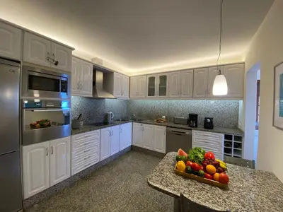 a kitchen with white cabinets and a bowl of fruit on a counter at Holiday Home Ideales Familienhaus mit freiem Stadt- und Meerblick by Interhome in Funchal