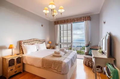 a bedroom with a bed and a window and a television at GuestReady - Charming retreat in Funchal in Funchal