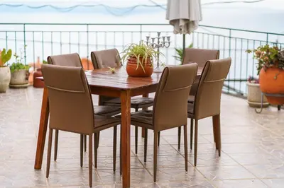 a wooden table and chairs with plants on a balcony at GuestReady - Charming retreat in Funchal in Funchal