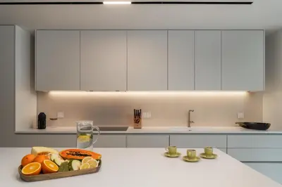 a kitchen with white cabinets and a tray of fruit at Savoy Monumentalis XII Comfort with Pool in Funchal