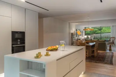 a kitchen with white cabinets and a bowl of fruit on a counter at Savoy Monumentalis XII Comfort with Pool in Funchal