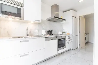 a white kitchen with white cabinets and appliances at Calas Loft by Atlantic Holiday in Funchal