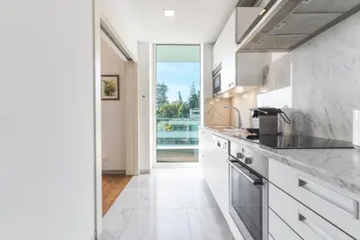 a kitchen with white cabinets and a large window at Calas Loft by Atlantic Holiday in Funchal