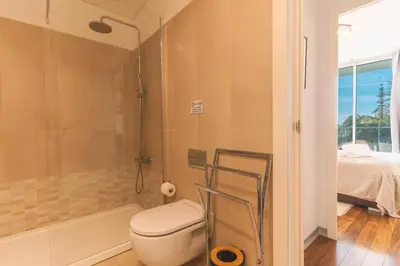 a bathroom with a toilet and a shower and a bed at Calas Loft by Atlantic Holiday in Funchal
