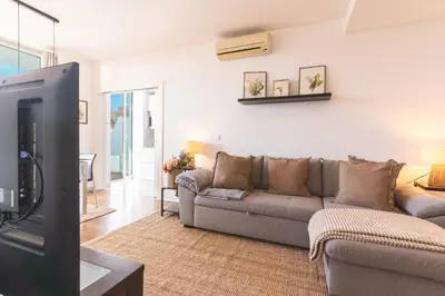 a living room with a couch and a tv at Calas Loft by Atlantic Holiday in Funchal