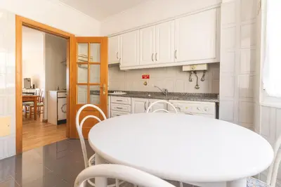 a kitchen with a white table and a white counter top at Sunrising Apartment by Atlantic Holiday in Caniço