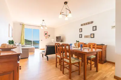 a dining room and living room with a table and chairs at Sunrising Apartment by Atlantic Holiday in Caniço
