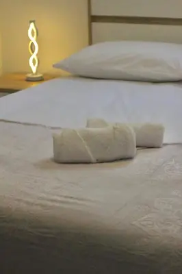 a white bed with a rolled up towel on it at Yara House in Câmara de Lobos