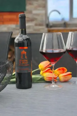 a bottle of wine and two glasses on a table at Yara House in Câmara de Lobos