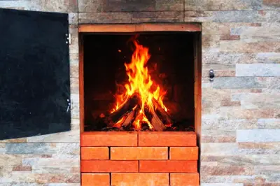 a fire in a brick oven with flames in it at Yara House in Câmara de Lobos