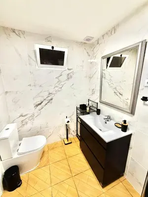 a bathroom with a sink and a toilet and a mirror at Yara House in Câmara de Lobos