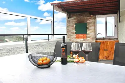 a table with a bottle of wine and two glasses at Yara House in Câmara de Lobos