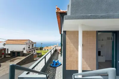 a white kitchen with a sink and a refrigerator at Casa Pereira in Ponta do Pargo