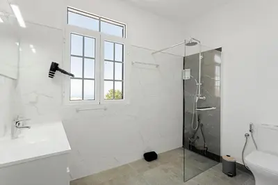 a white bathroom with a sink and a mirror at Casa Pereira in Ponta do Pargo