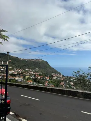 a road with a view of a city and the ocean at Casa do Arco in Arco da Calheta