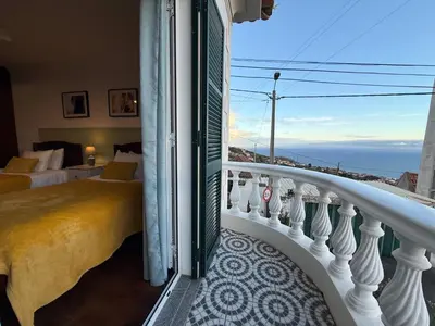 a bedroom with a balcony with a view of the ocean at Melody House of Ponta do Sol in Canhas