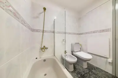 a white bathroom with a toilet and a bath tub at Melody House of Ponta do Sol in Canhas