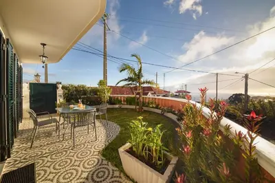 a patio with a table and chairs and plants at Melody House of Ponta do Sol in Canhas
