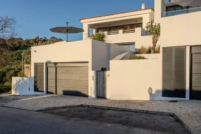 a bedroom with a large bed and a large window at Exclusive Luxury Villa Pool & Ocean View Salema in Budens