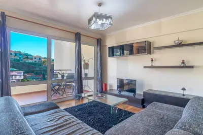 a living room with two couches and a large window at Vista Calheta Apartment in Calheta