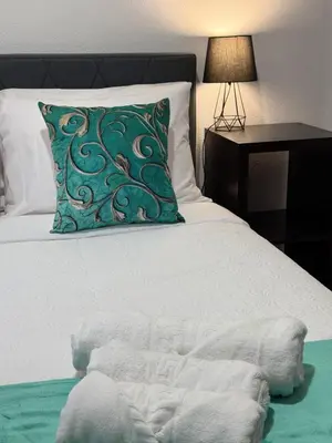 a bed with a green pillow and a night stand at Ocean View Guest House in São Vicente